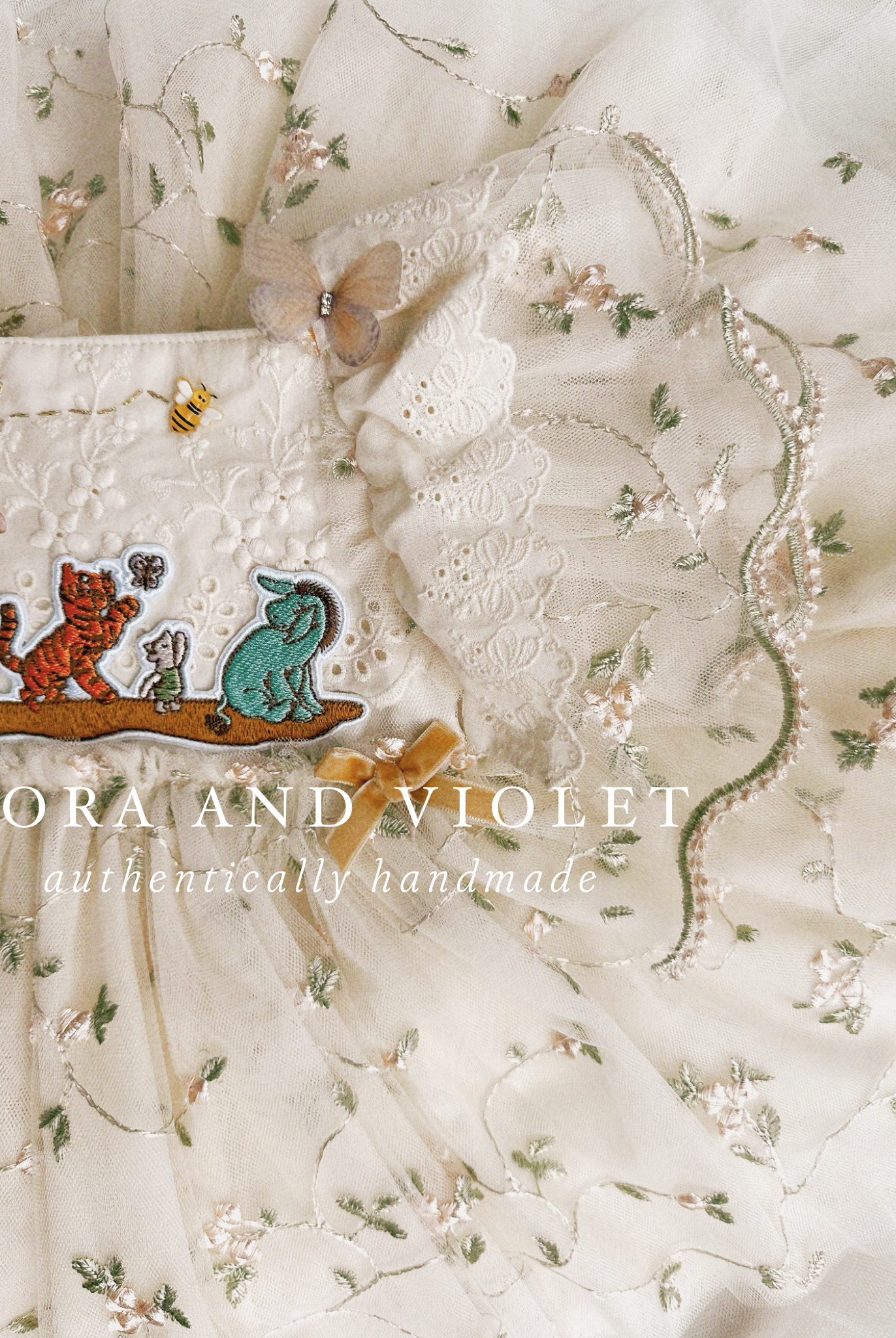 closue up shot artisan-stitched rosebuds and hand-applied butterflies on a luxury classic pooh milestone gown.