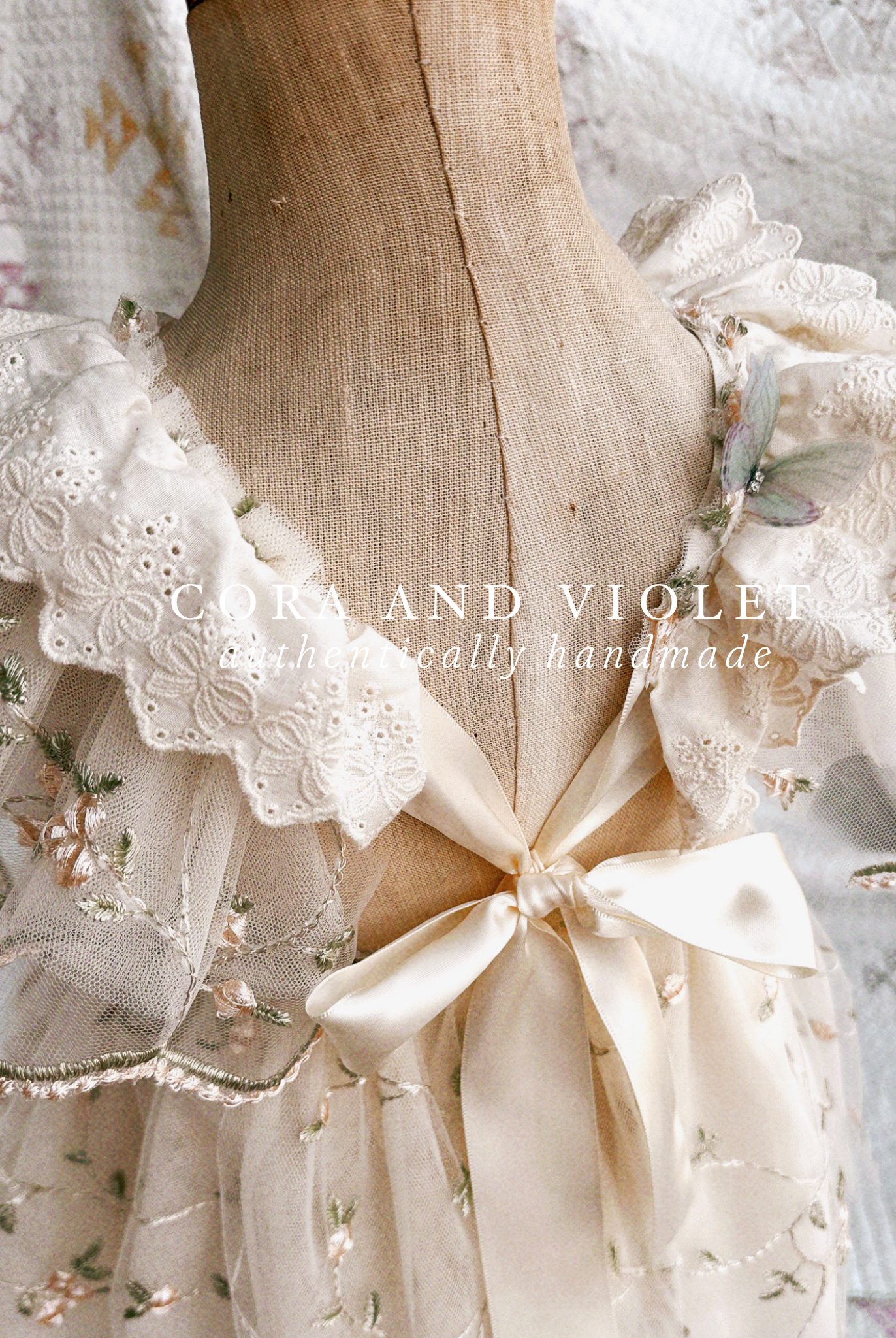 Close-up of artisan-stitched rosebuds and hand-applied butterflies on a luxury classic pooh milestone gown.