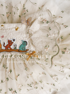 closue up shot artisan-stitched rosebuds and hand-applied butterflies on a luxury classic pooh milestone gown.