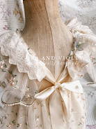 Close-up of artisan-stitched rosebuds and hand-applied butterflies on a luxury classic pooh milestone gown.