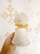 Close-up of vintage-style embroidered lace and hand-tied bow on a luxury heirloom party hat. cora and violet party hat  first birthday accessories baby girl